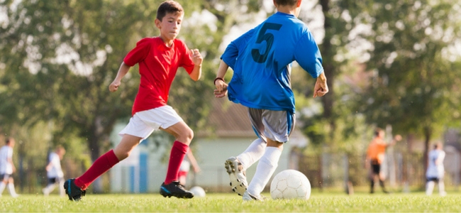 Children playing football on grass