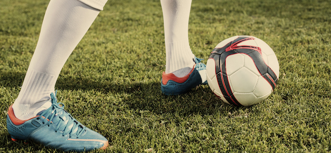 Football cleats and ball on grass