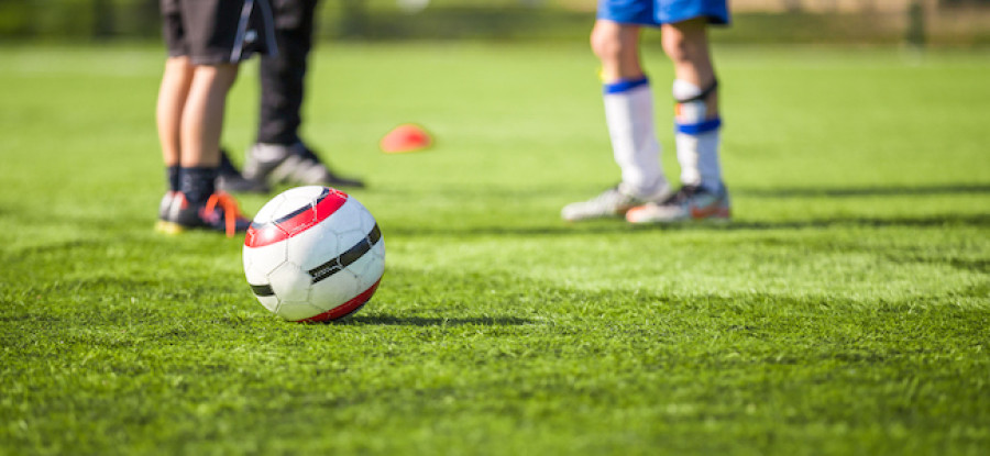 Football on the field next to players