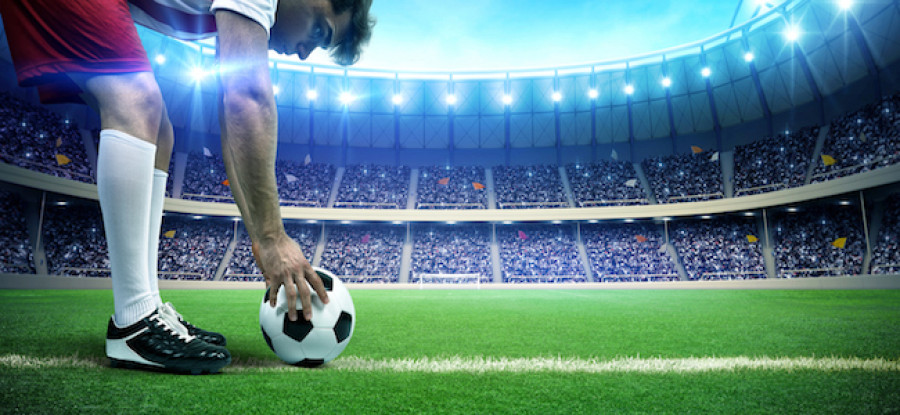 Football player setting up ball on field