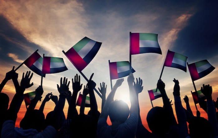 Group of people waving UAE flag