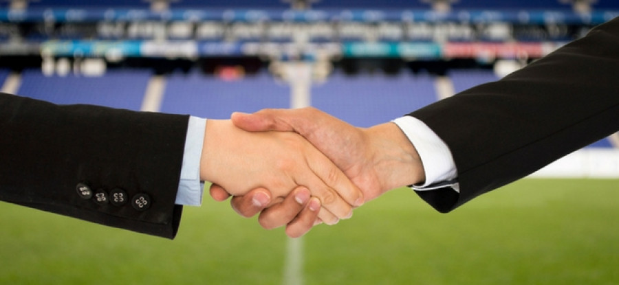 Handshake with football field in background