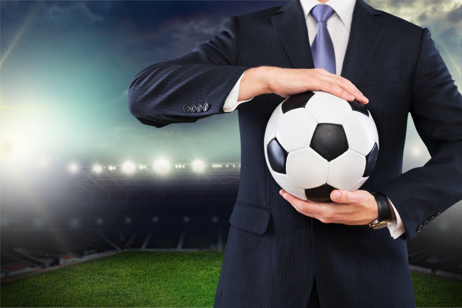 Man wearing suit holding football