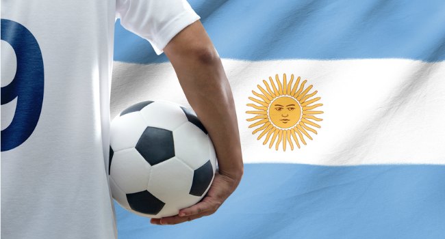 Player_Holding_Football_in_front_of_Argentinian_Flag