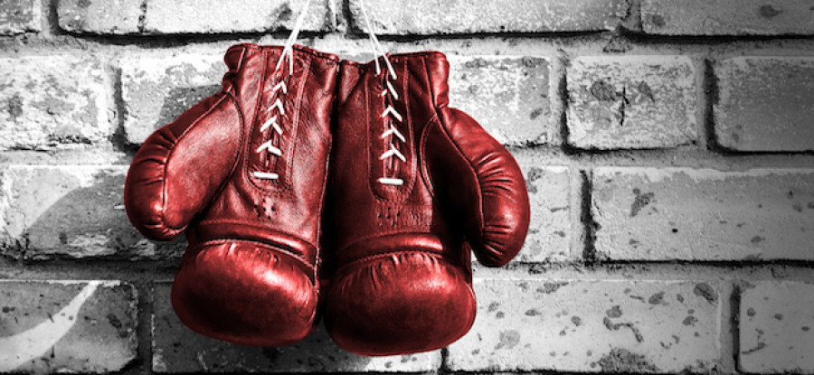 Red boxing gloves hanging on brick wall