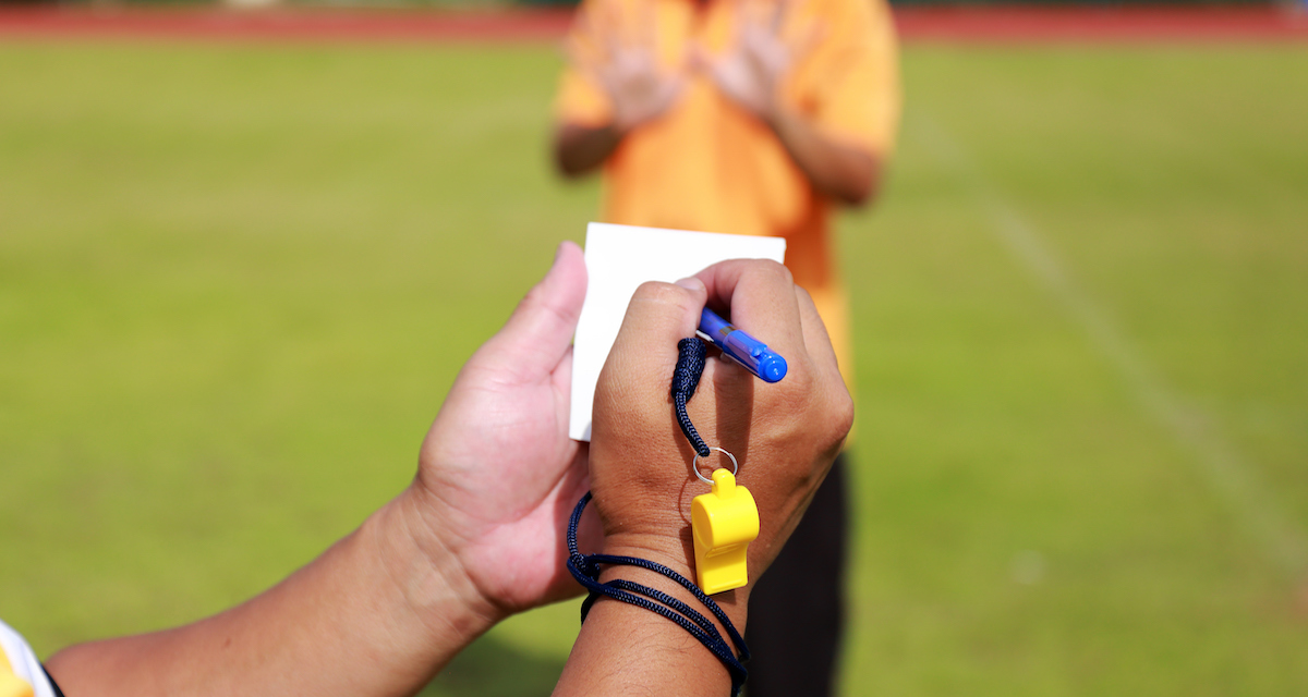 Referee writing on notepad