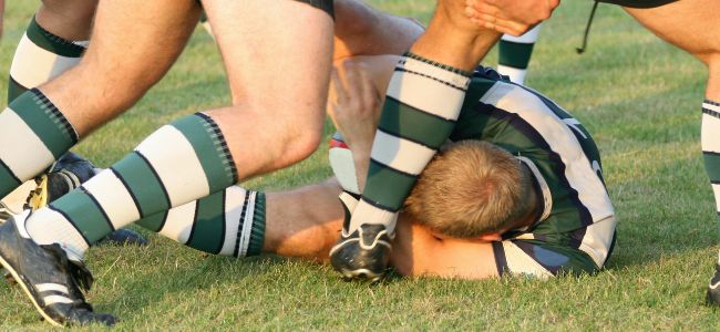 Rugby_Player_on_ground_under_legs