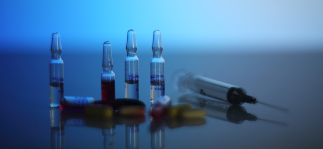 Syringe and capules on blue background