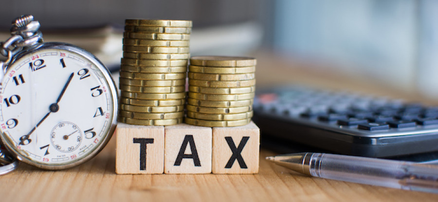 Tax woodblock letters under coins on table