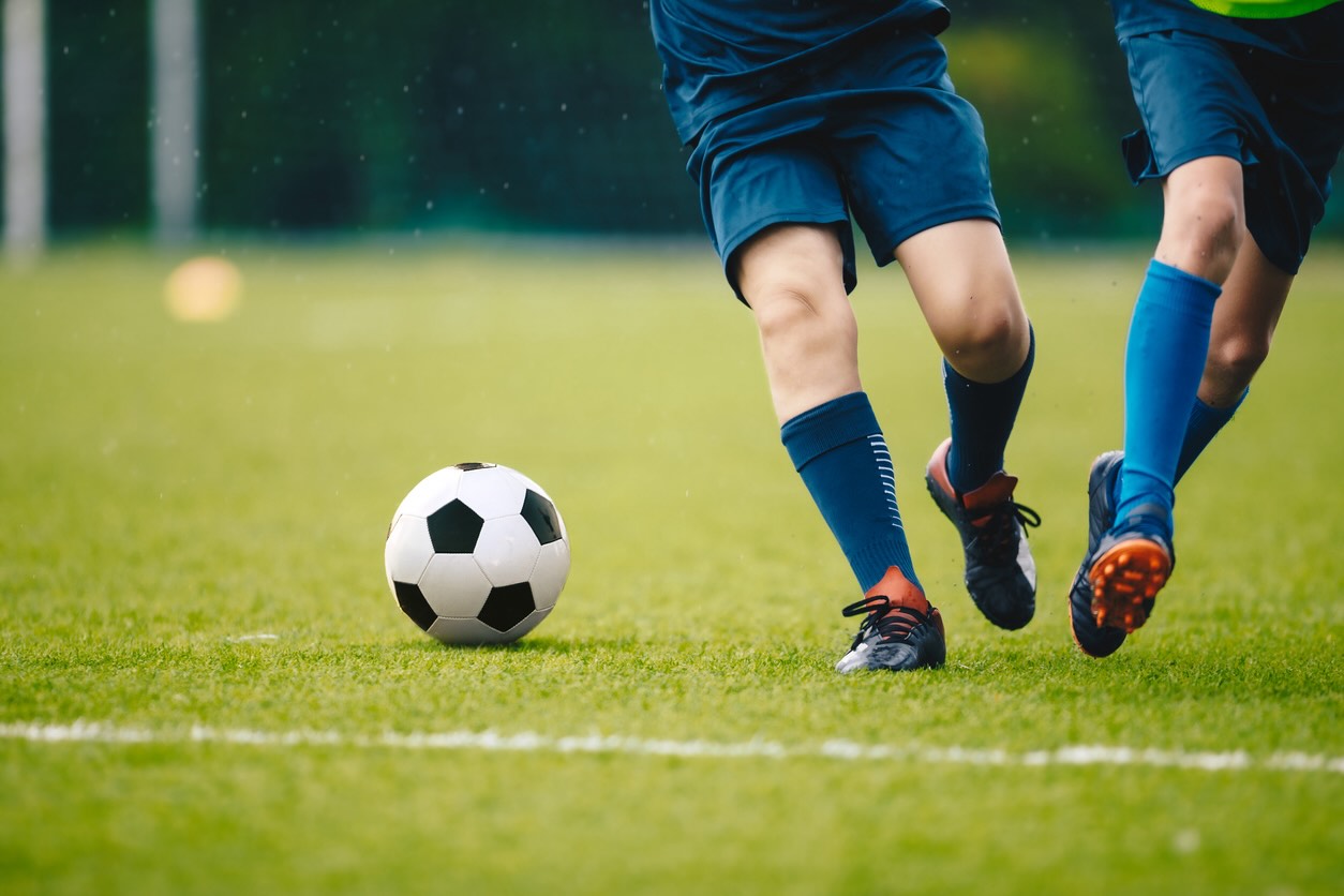 Two footballers challenging for the ball