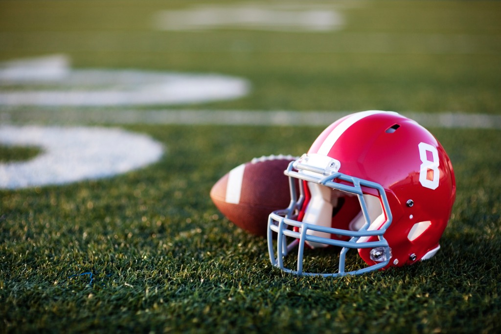 American Football Helmet and Ball On A Field