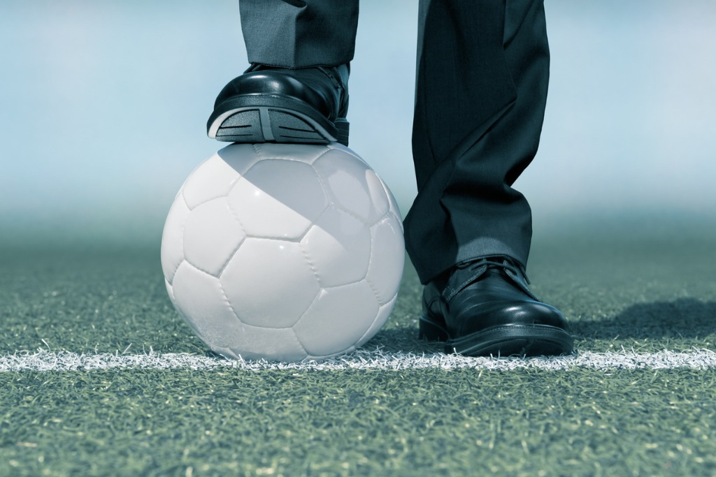 Business man standing on a football