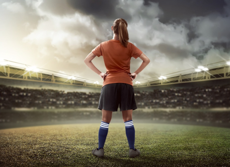 Female Footballer Standing on Pitch