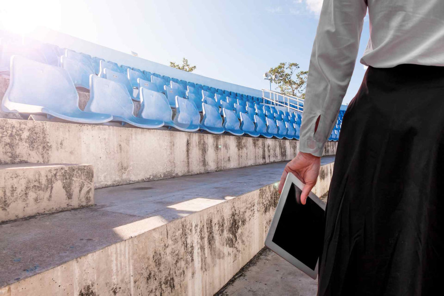 Picture of lady holding ipad at old football stadium