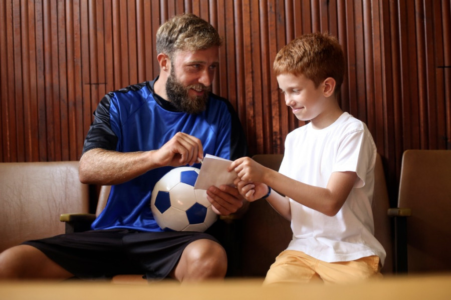 Athlete giving autograph to child