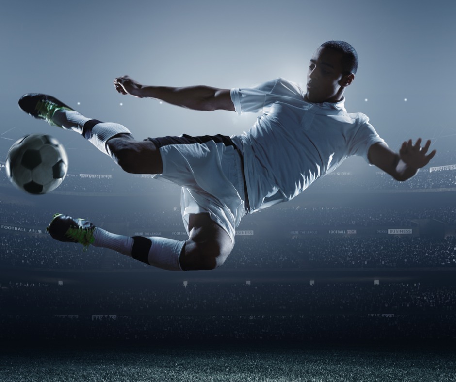 Footballer Kicking Ball In Stadium