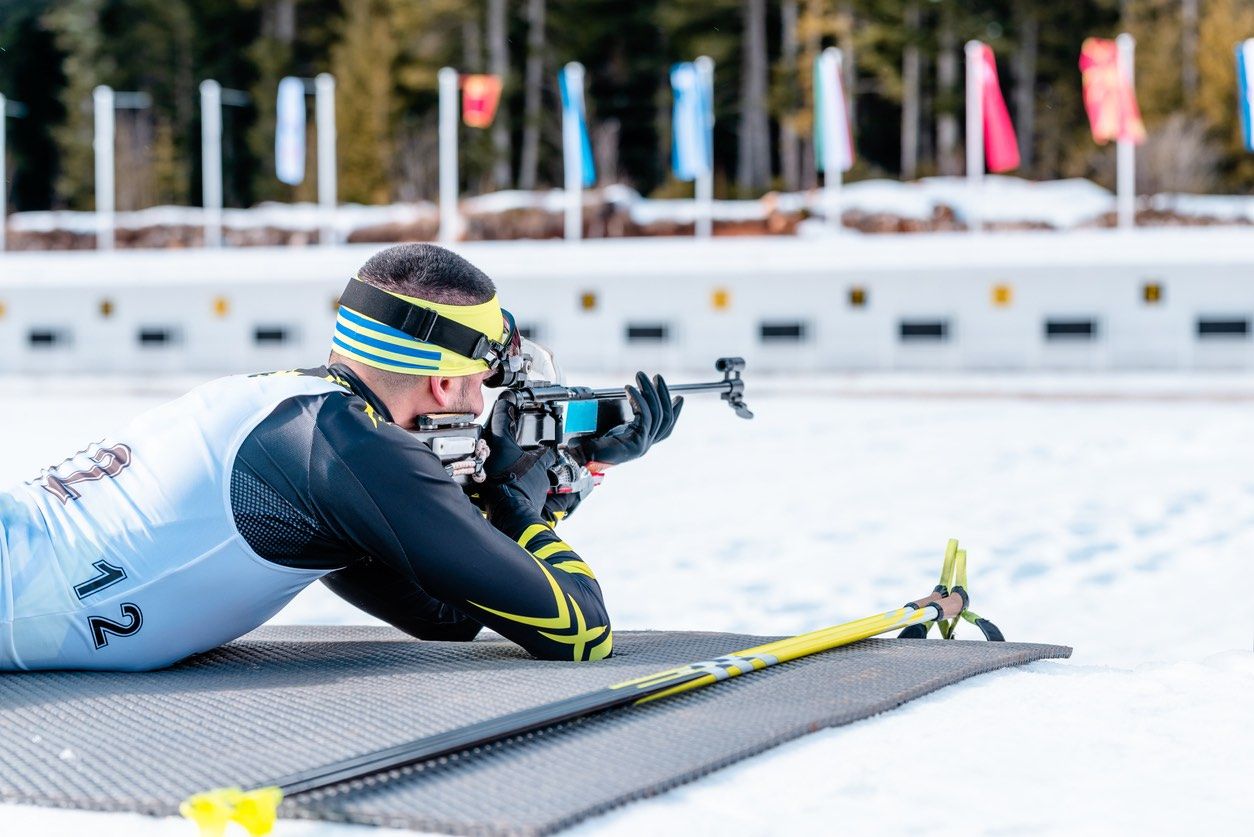 Biathlete shooting with rifle